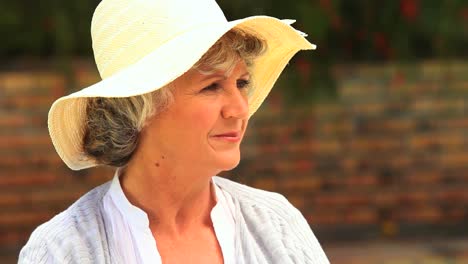 woman wearing a hat posing and smiling for the camera