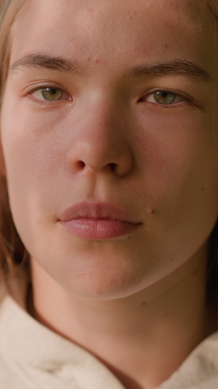 primer plano de una mujer joven mirando atentamente con la suave luz del sol que se refleja en su cara, creando una expresión pacífica, mientras que la vegetación borrosa y las hojas que se balancean suavemente llenan el fondo