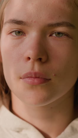 close-up of young woman looking intently with gentle sunlight reflecting on her face, creating a peaceful expression, while blurred greenery and gently swaying leaves fill the background
