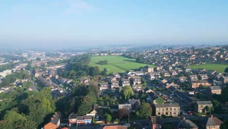 Dewsbury-Moore-Council-estate,-UK,-is-captured-by-a-drone,-highlighting-red-brick-homes-and-the-industrial-Yorkshire-scenery-on-a-sunny-summer-morning