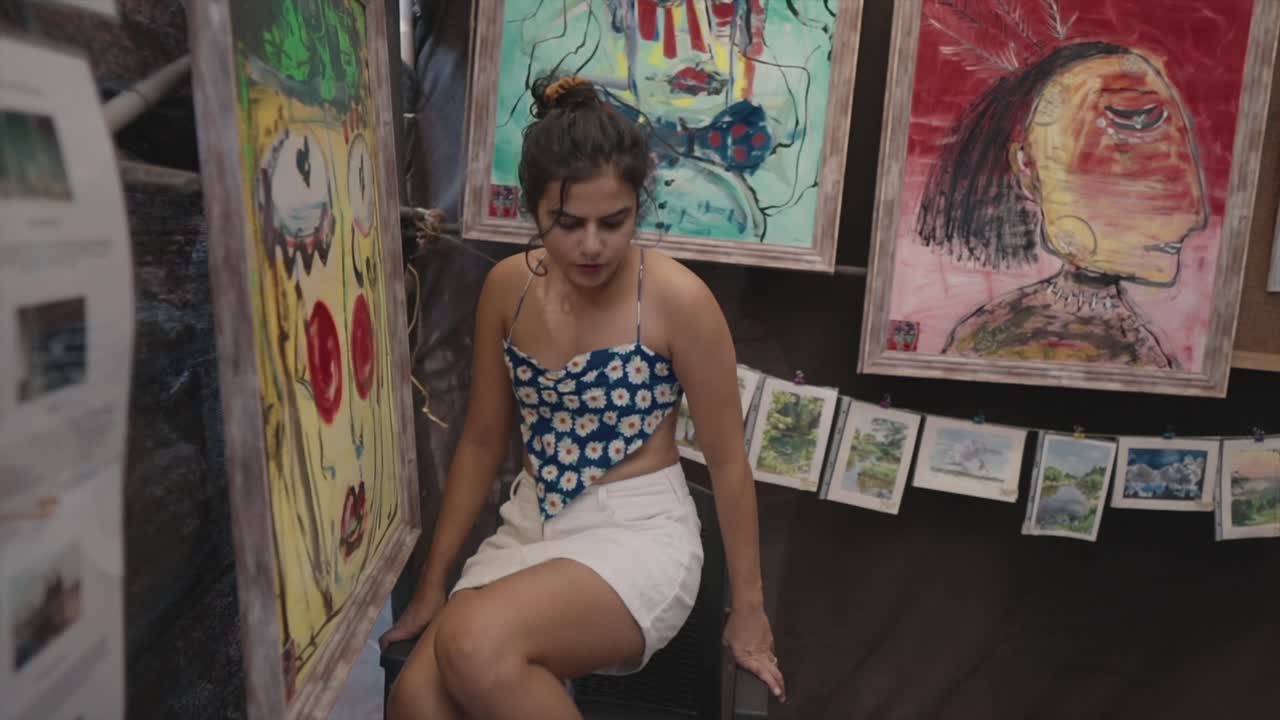 una galería de arte trabajando bajando la escalera después de colgar una pintura