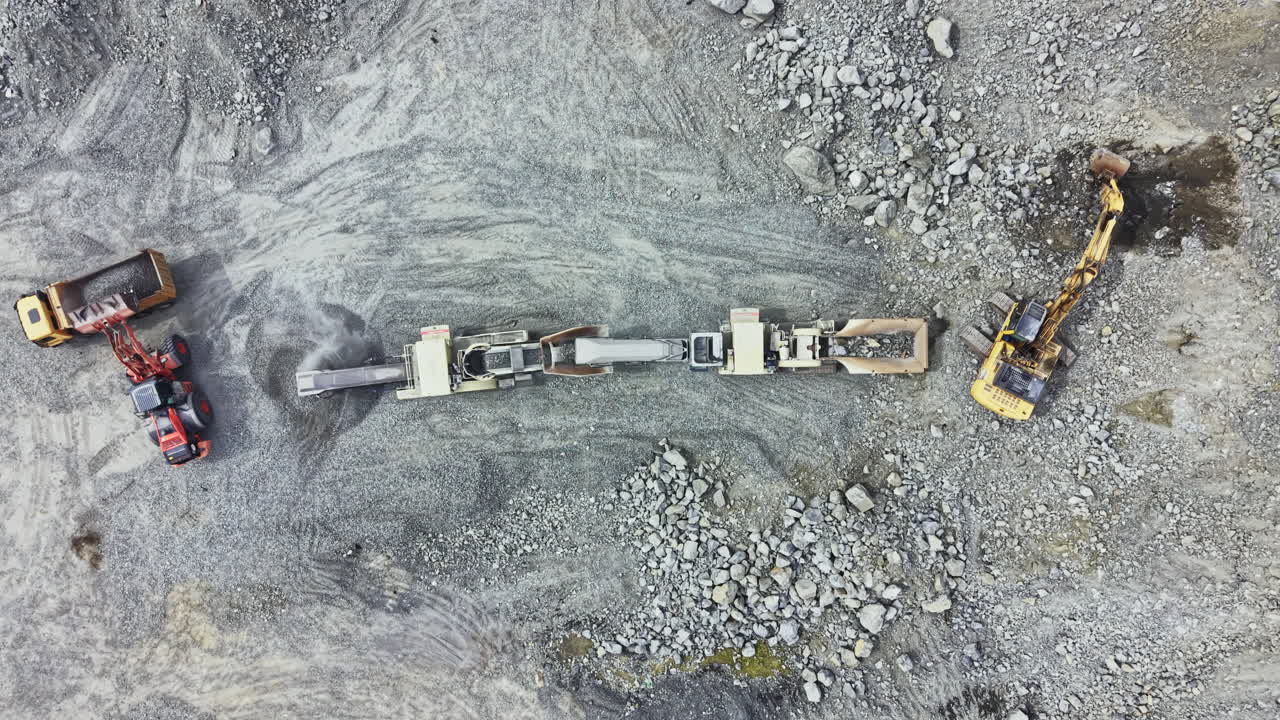 Granite quarry operation with machines working on site to extract stone materials during daytime