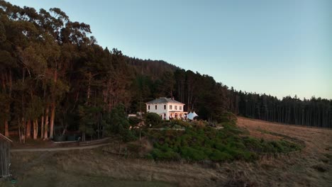 wide drone shot pushing towards a private wedding venue in california's countryside at sunset