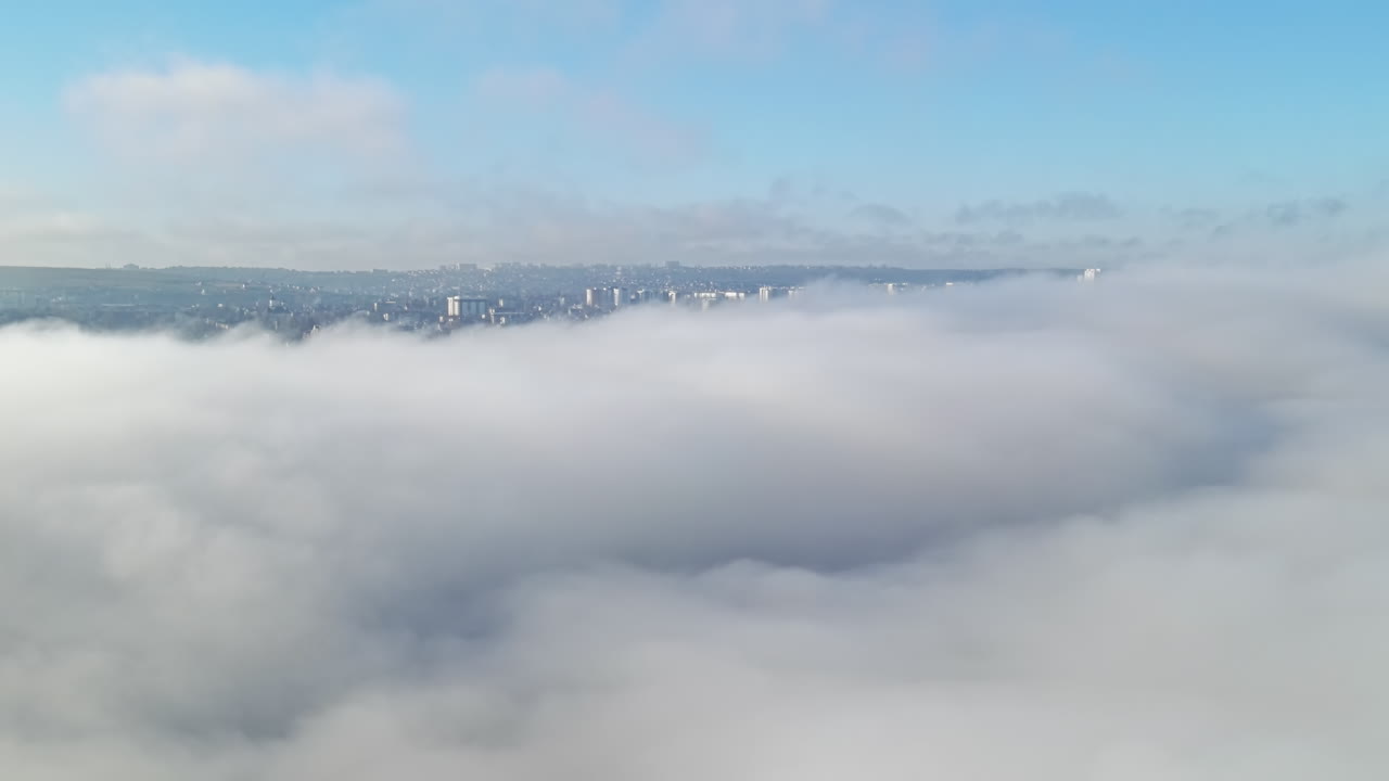 Aerial drone view above the clouds with buildings visible through, Chisinau, Moldova