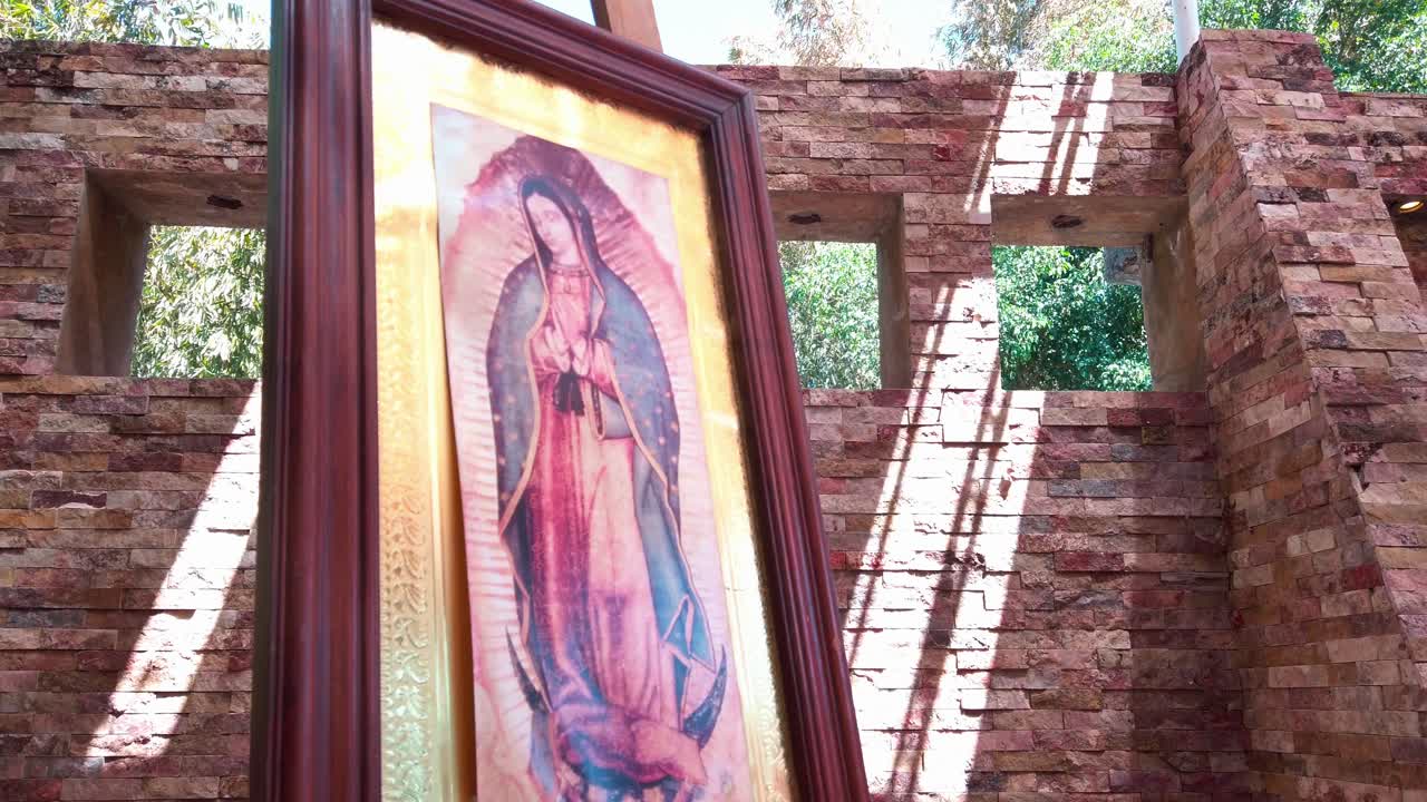 Framed image of Virgin Mary in sunlit brick plaza, peaceful and sacred atmosphere