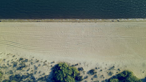 El-Rompido-City---Aerial-top-down-descending-on-Sandy-Beach-Coastline-When-Few-Undecognizable-People-Standing-Waterfront