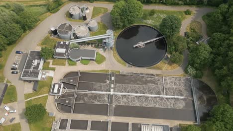 aerial top-down drone view of a modern water treatment plant with multiple circular filtration basins.