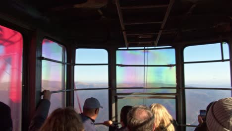 Inside-of-a-crowded-mountain-ski-lift-in-the-carpathian-mountains-crossing-a-tower-during-autumn