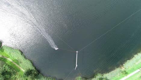 disparo aéreo de un avión no tripulado de una persona haciendo wakeboard a través de una curva