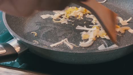 close-up of frying pan and roasting onions on finely chopped