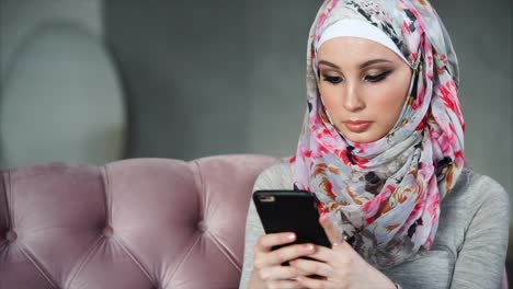 woman in hijab using smartphone
