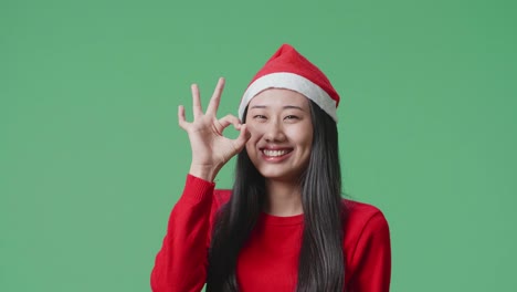 woman wearing santa hat with ok hand gesture