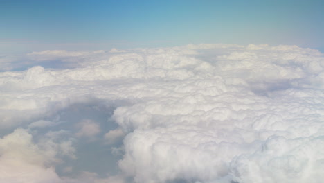 Like-groups-of-fluffy-marshmallows,-clouds-stand-together-along-blue-skyline