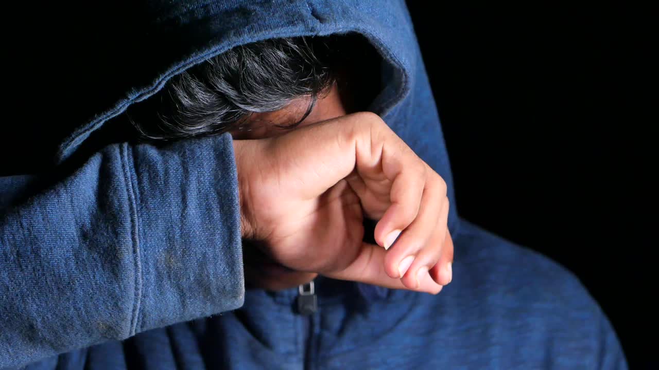 슬픈 사람이 후디에 얼굴을 숨기고