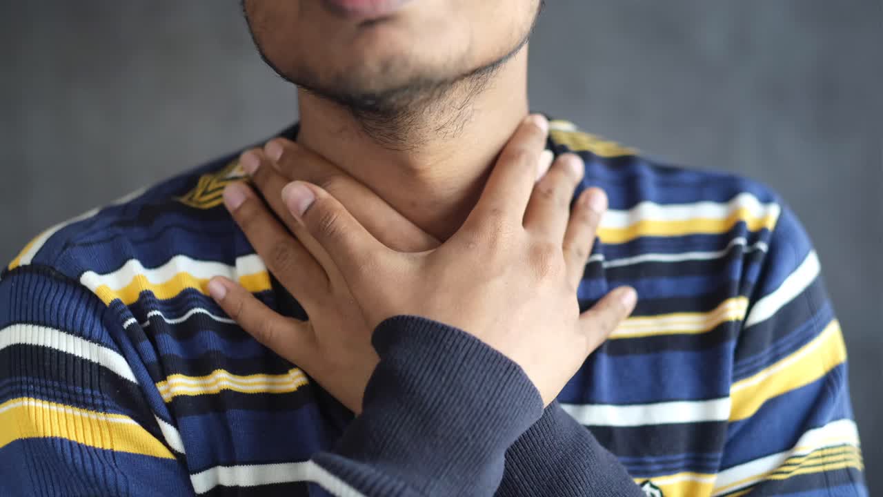 hombre tocando su dolor de garganta