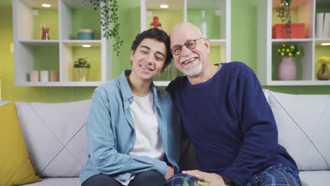 el abuelo feliz y el nieto lindo miran a la cámara con una sonrisa.