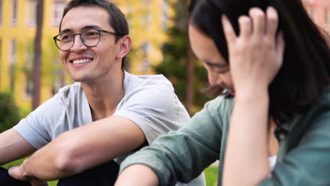 Zwei-Japanische-Freunde-Unterhalten-Sich-Und-Lachen,-Während-Sie-Im-Freien-Zusammensitzen-1