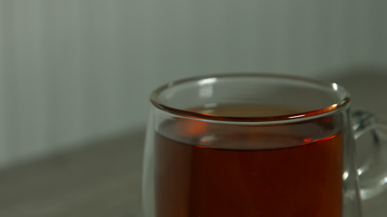 Tè in tazza di vetro trasparente su tavolino da caffè