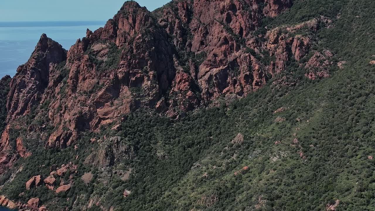 Le montagne si ergono lungo la costa della Corsica, in Francia, in una giornata di sole