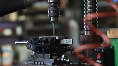 skilled machinist working intently on a large industry in metal factory workshop with large machines