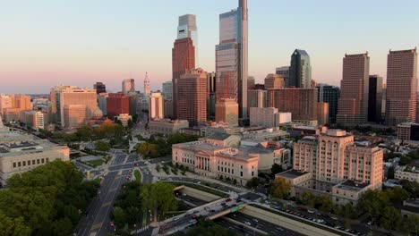 Aerial-descending-push-in-toward-Philadelphia's-skyline-and-Benjamin-Franklin-Parkway-during-summer-dusk