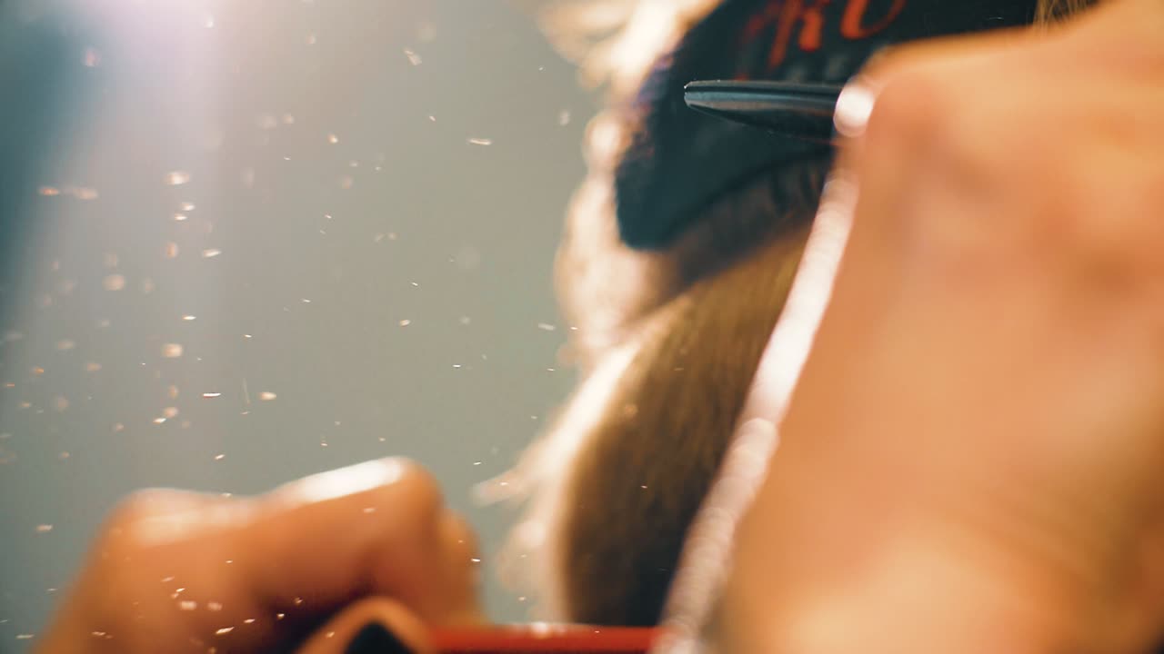 머리카락 스타일리스트가 가위로 미용실 고객의 머리카락을 잘라내는 느린 동작