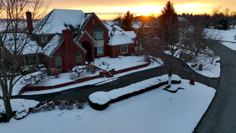 large brick mansion home in winter snow sunset