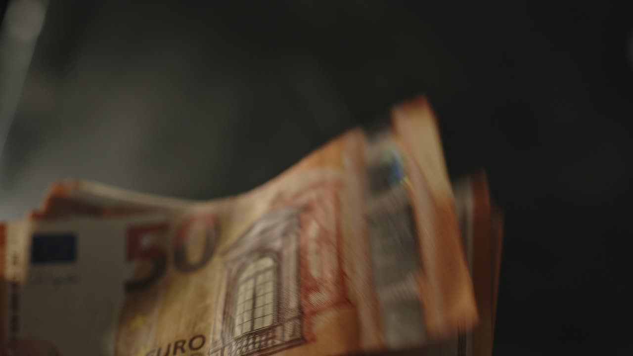 Mano che sventola una grande pila di banconote da 50 euro al rallentatore