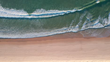 Una-Cálida-Playa-De-Arena-Naranja-Con-Olas-Y-Espuma-Blanca