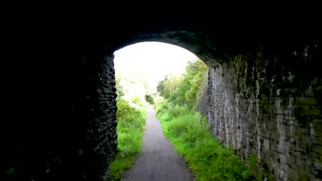 an aerial drone shot through a tunnel and over a valley in south wales