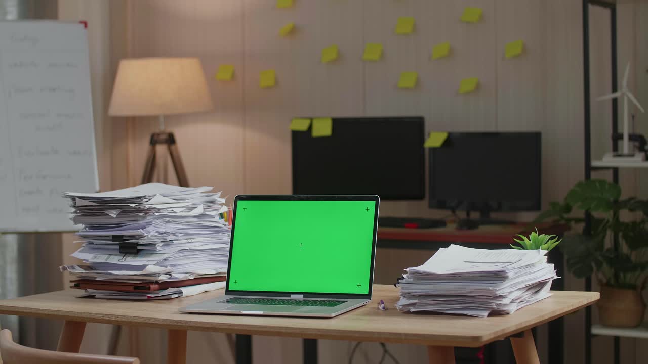 Green Screen Laptop With Documents On The Table At The Office