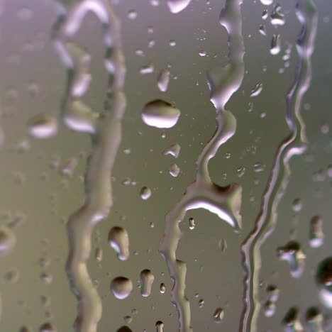 water drops on glass. large rain drops strike a window pane during a summer shower. pure rain drops