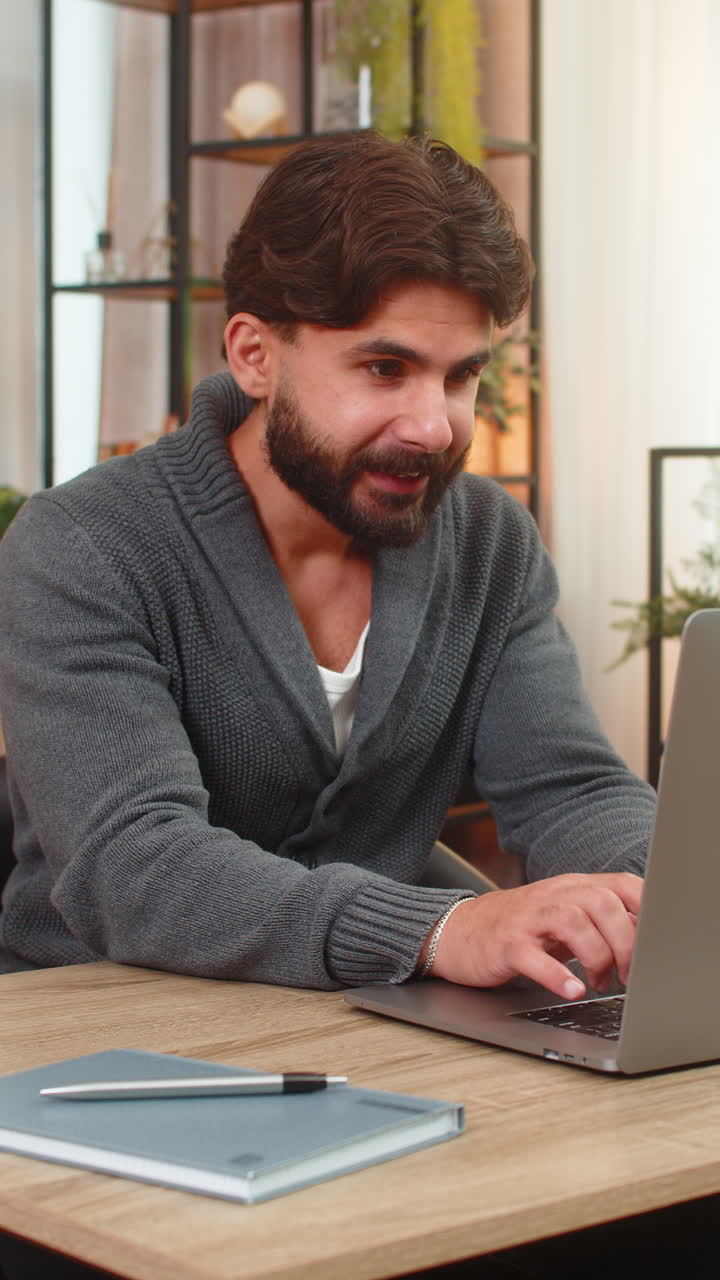 Indian man gets email confirmation of partnership on laptop surprised smiles thumbs up big approval