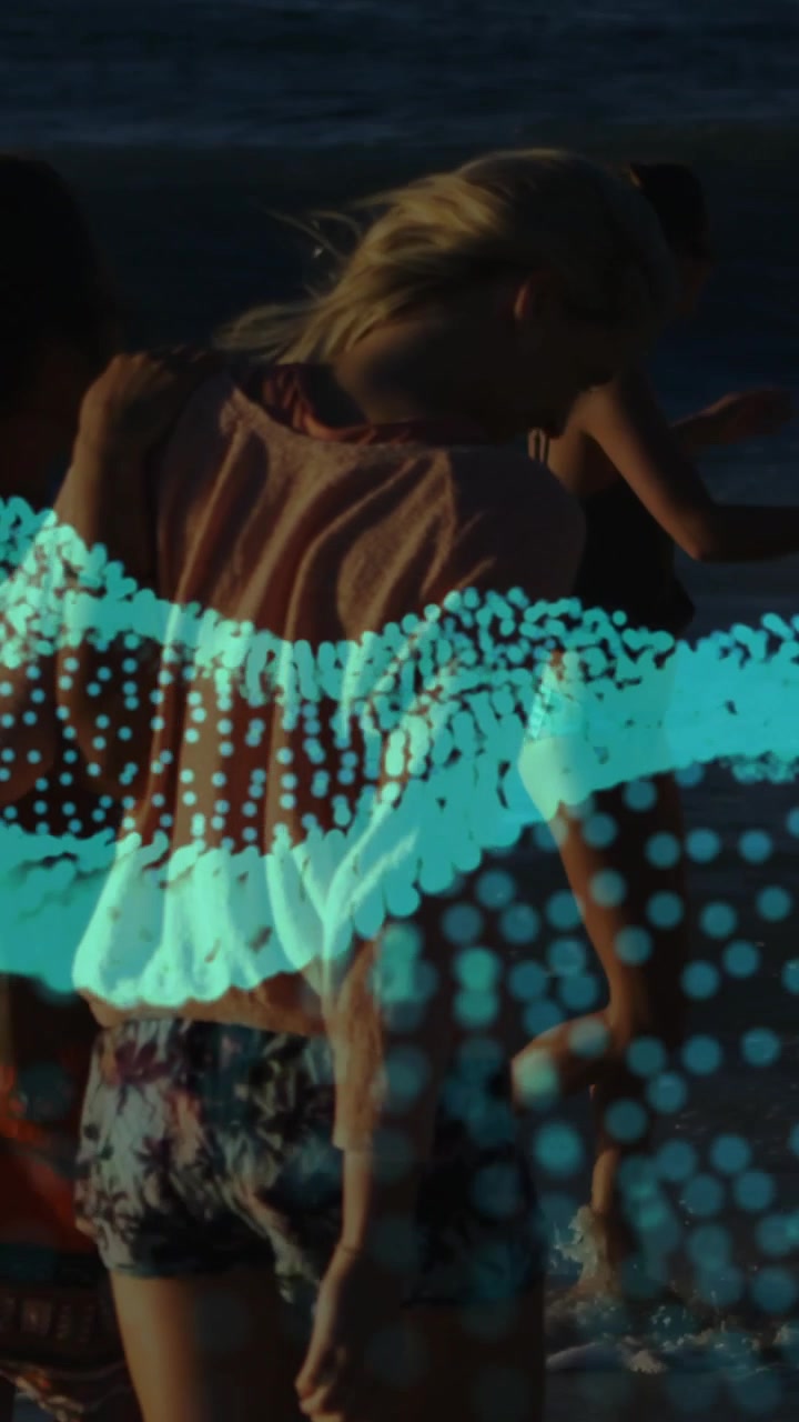 Video verticale: Pubblicità che mostra una donna che cammina sulla riva al tramonto, con sovrapposizione di punti verde acqua che si muovono ai piedi, e un adolescente che si unisce.