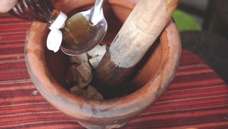 serie de cocina som tam: cámara lenta, vendedor de comida callejera que pone salsa de pescado en el mortero para hacer som tam o ensalada de papaya verde picante tailandesa, uno de los platos más populares de tailandia