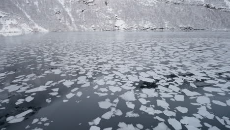 Zeitlupen-POV-Einer-Winterfahrt-Mit-Der-Fähre-Im-Geirangerfjord-Nach-Geiranger,-Norwegen,-Bei-Der-Eis-Zu-Sehen-Ist,-Das-Von-Den-Bergen-Im-Fjord-Treibt