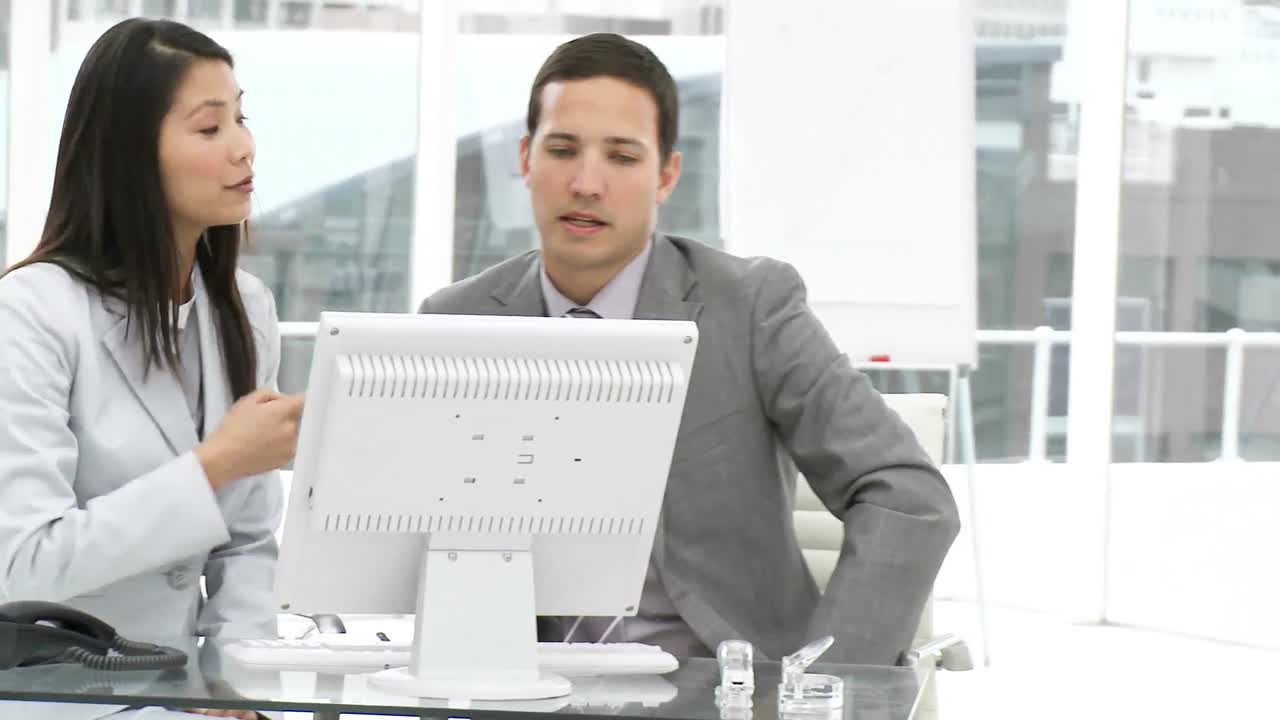 두 동료 가 컴퓨터 에서 일 하고 있다