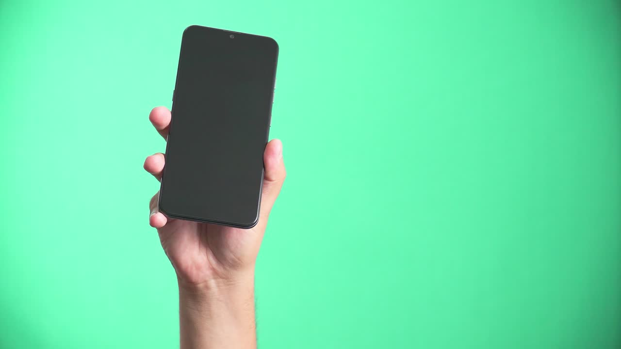 A person holding a cell phone with his hand. 4k green screen