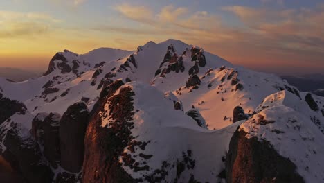 sunset over snowy ciucas mountains with warm glow