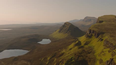 Aerial drone footage of the dramatic mountain landscapes on the Isle of Skye, Scotland. Sweeping panoramic views of majestic peaks, green valleys, and wild nature