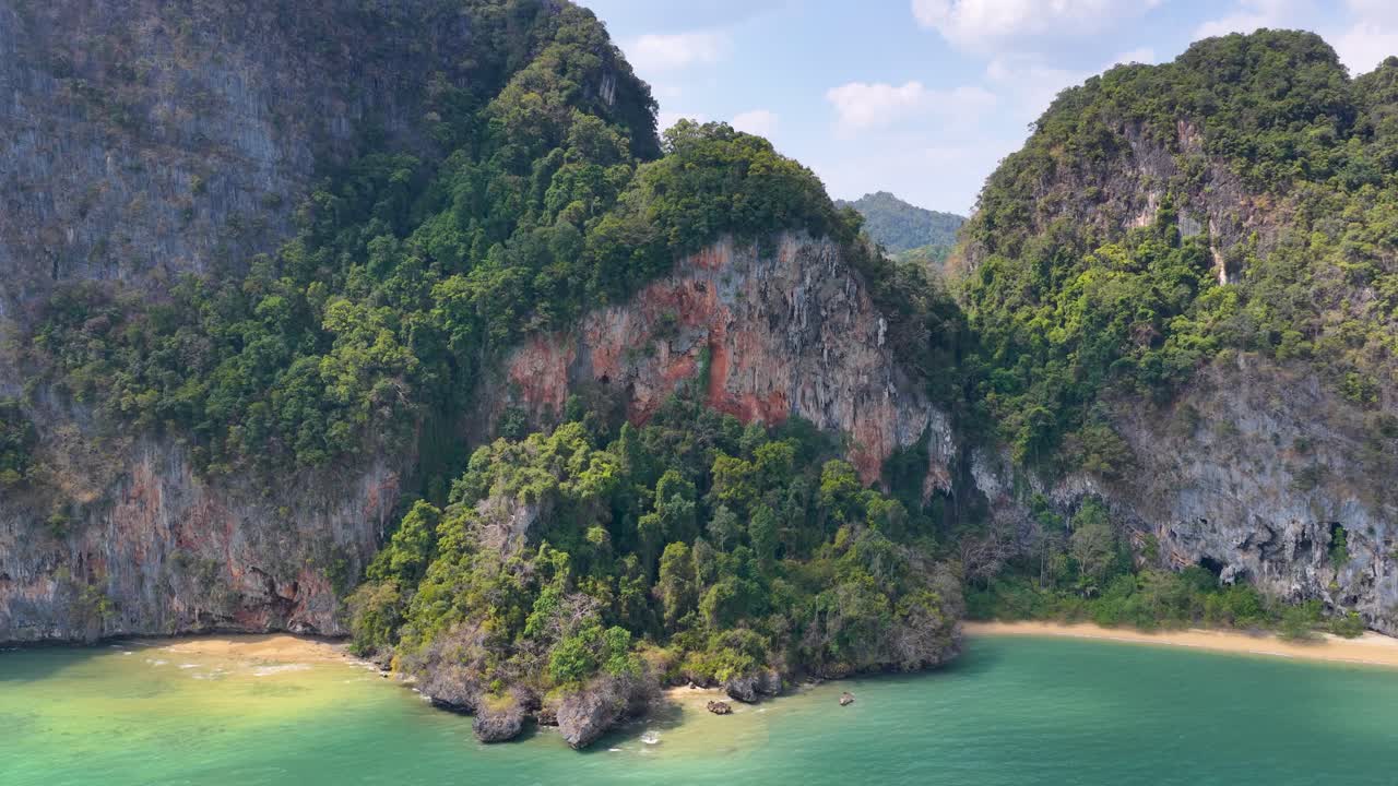 Un drone riprende imponenti scogliere calcaree e l'acqua turchese dell'oceano a Krabi, Thailandia.