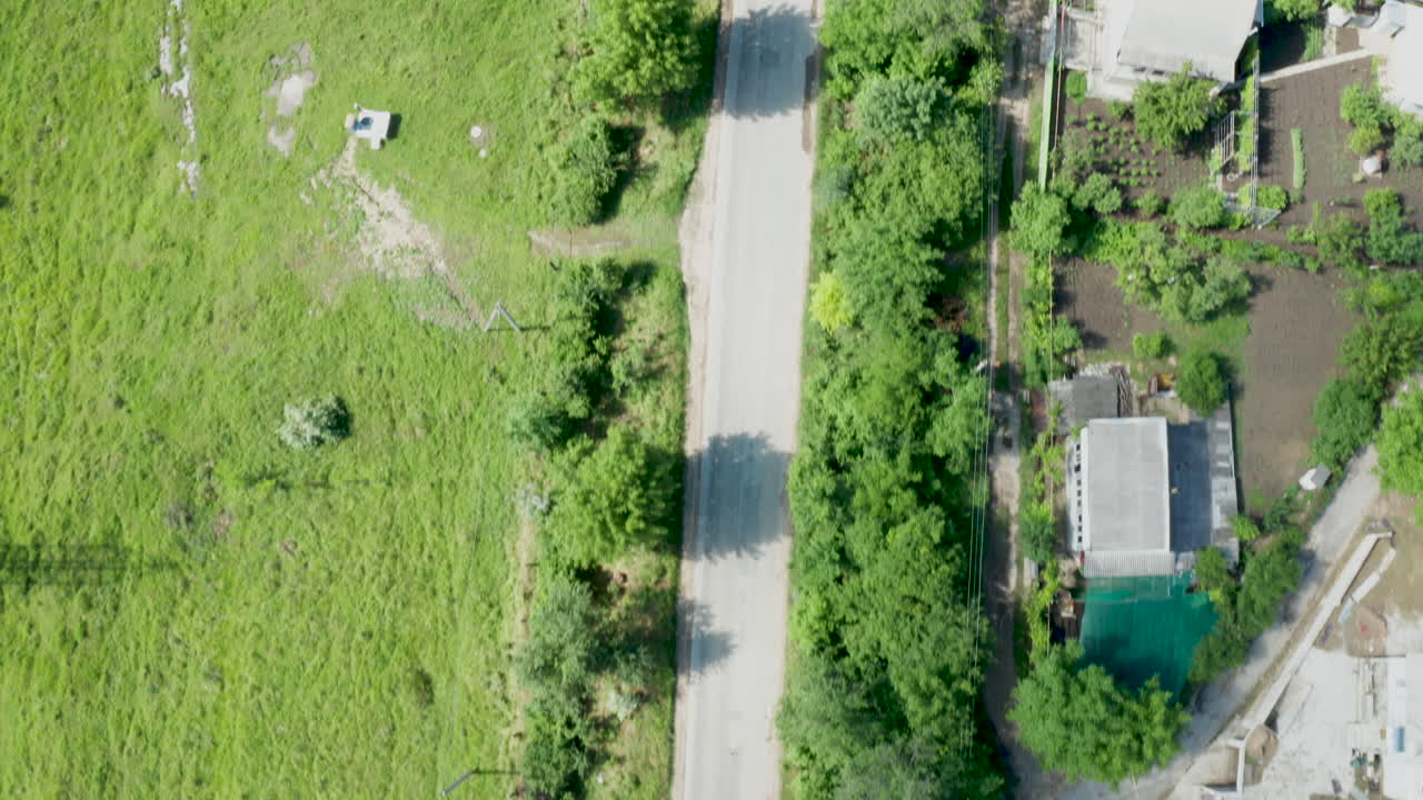 Aerial view of a village with roads, trees, and buildings