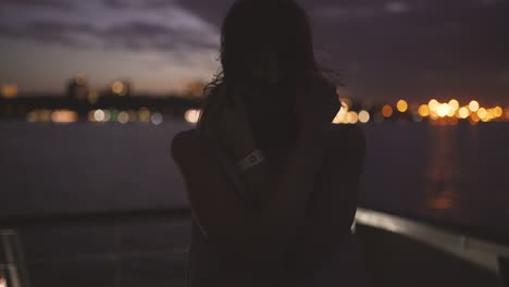 silhouette of a young happy girl feeling awesome and dance on the ship at dark night