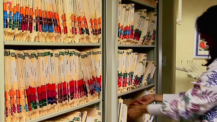 Un operatore sanitario archivia la cartella clinica di un paziente.
