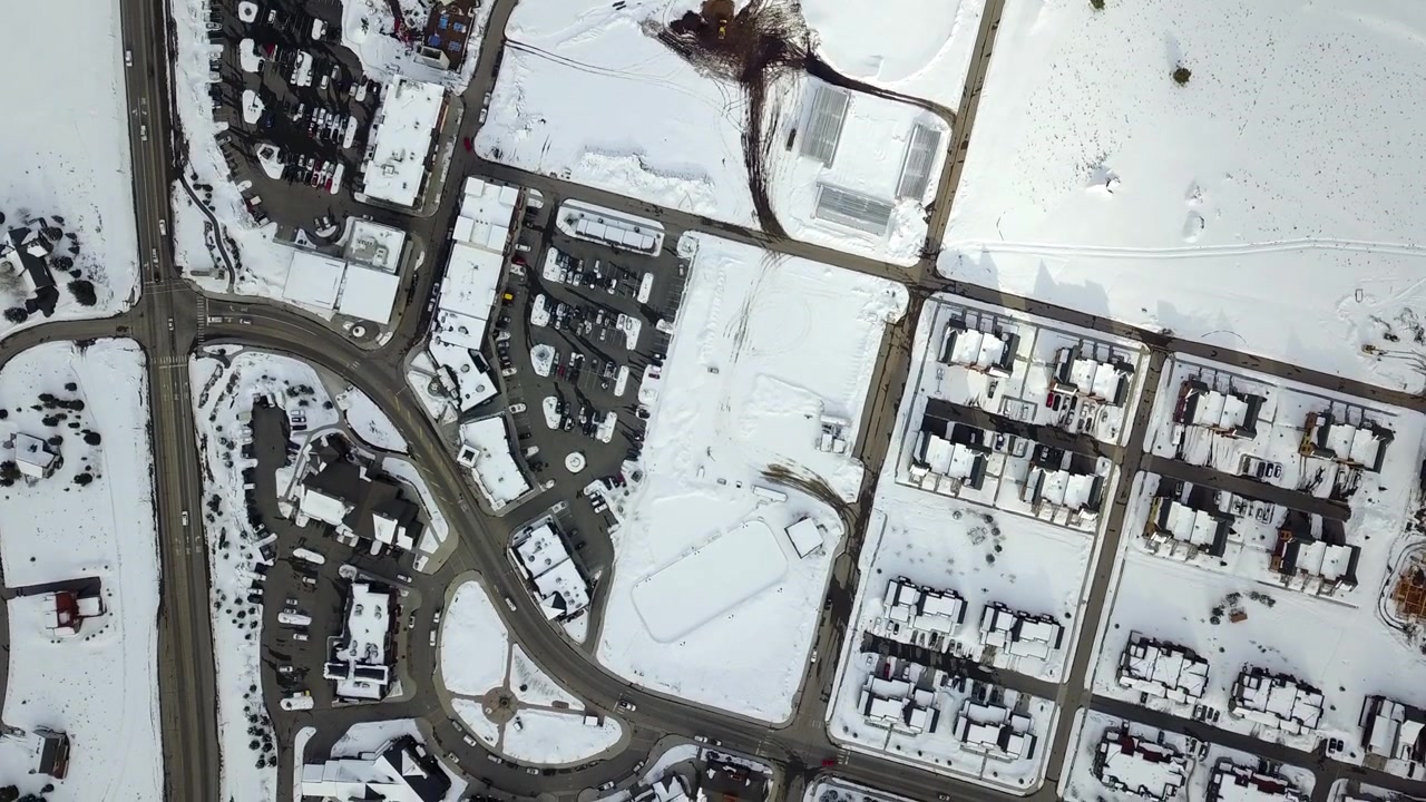 Overhead aerial view of traffic driving through streets in the winter