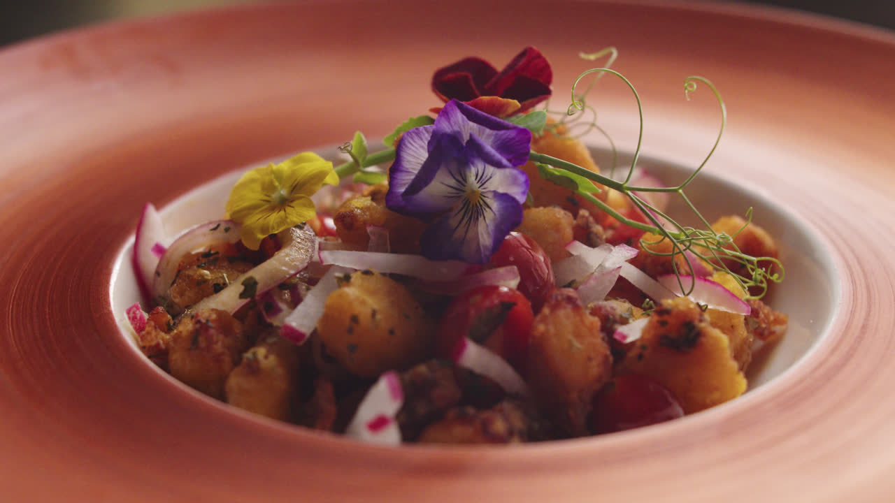 Chef Garnishing a Gourmet Dish with Edible Flowers
