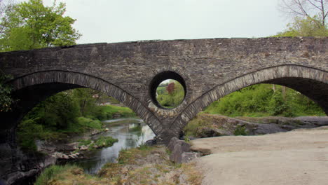 wide shot of the cenarth bridge with tractor crossing at cenarth falls on the river teifi