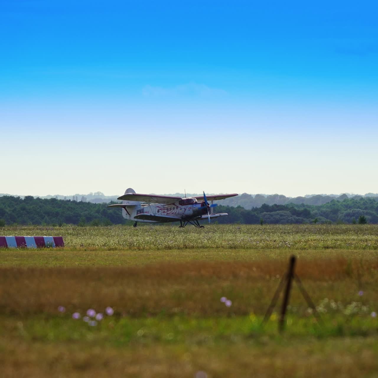 Compact aircraft taking off from the field. Start of a flight. Blue skies at backdrop