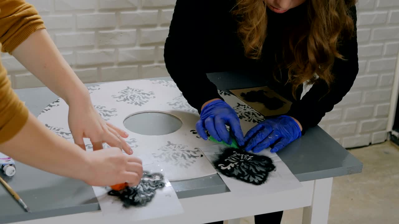 mujeres decoradoras, diseñadoras pintando decoración de círculos de madera