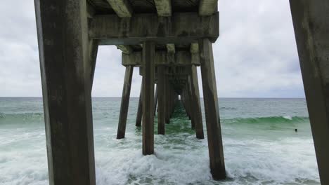 Imágenes-Aéreas-épicas-Bajo-El-Muelle-Del-Océano-Pensacola-En-La-Costa-Del-Golfo-De-Florida,-Cámara-Lenta